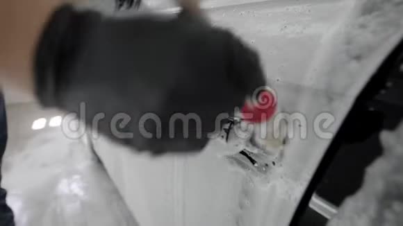 近距离拍摄一个男人用刷子清洁汽车手柄视频的预览图