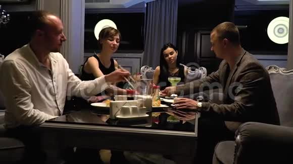 快乐的男人和女人坐在餐厅的沙发上吃寿司滑滑梯射击视频的预览图