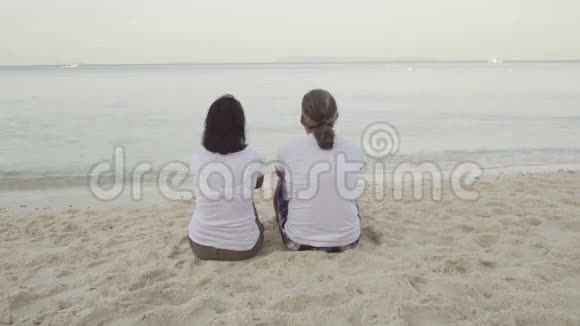 男人和女人坐在沙滩上视频的预览图
