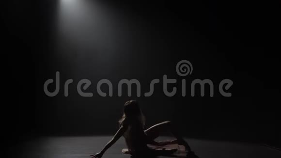 一个少女在黑暗的工作室里轻舞的动作视频的预览图