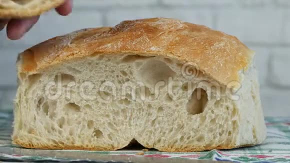 男人切片一个新鲜和美味的面包在桌子上视频的预览图