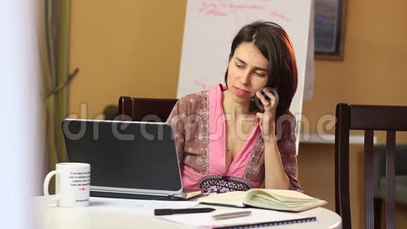 女人在咖啡馆里用手机聊天手提电脑浏览约会视频的预览图