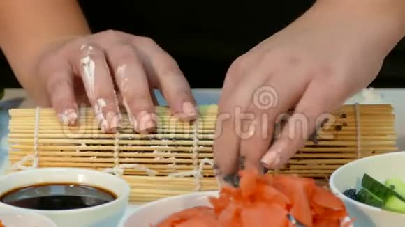 厨师用黑鲟鱼子酱装饰寿司卷视频的预览图