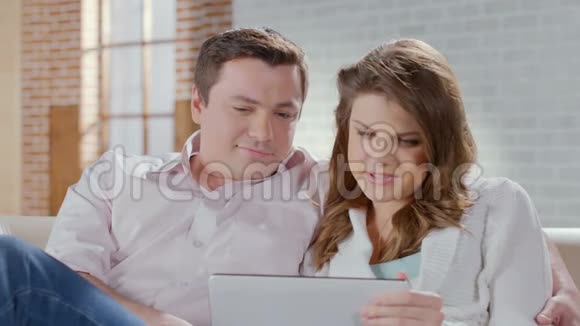 中年夫妇谈笑风生在平板电脑上看照片视频的预览图