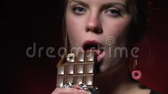 一个穿黑色夹克的女人正在吃巧克力棒有点慢动作视频的预览图