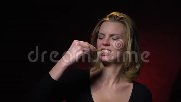 金发女郎咬着一只果冻虫摇着头发慢动作视频的预览图