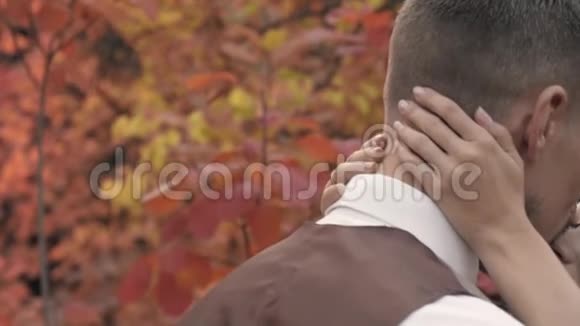 在秋天的公园里女人的手轻轻地抱着男人的头动作缓慢视频的预览图
