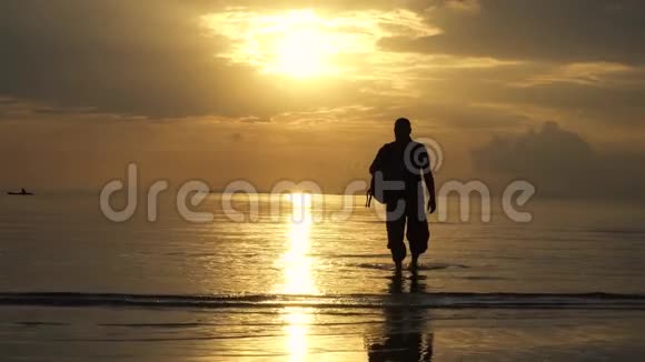 日落时分在海边漫步的男性背包客剪影视频的预览图
