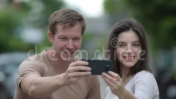年轻的幸福夫妇在户外的街上一起自拍视频的预览图