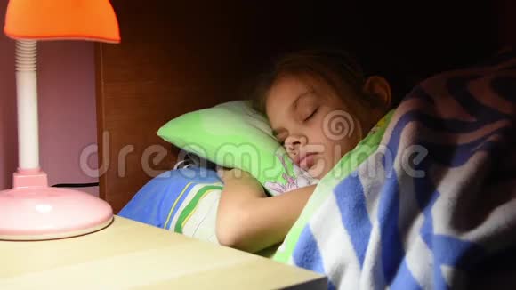 爸爸把毯子拉直了睡着了吻了吻她的女儿在床上关掉了台灯视频的预览图