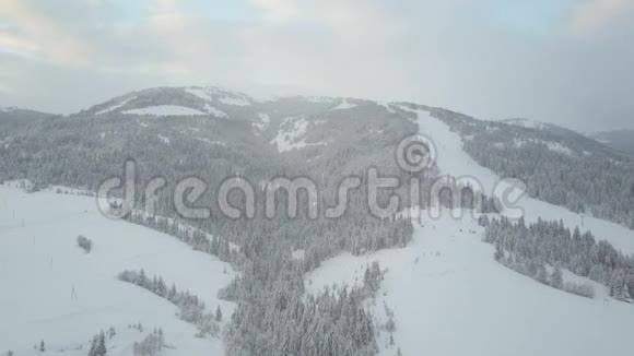 在喀尔巴阡山的滑雪场飞行鸟山上白雪覆盖的房子的视野农村视频的预览图