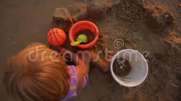 儿童玩球和水桶坐在沙滩上视频的预览图
