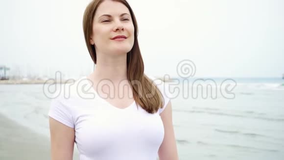年轻女子独自沿着海滩散步从地中海吹来的风慢慢地吹着她的头发视频的预览图