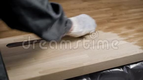 专业的木匠正在用一层油涂在磨砂的木头上视频的预览图