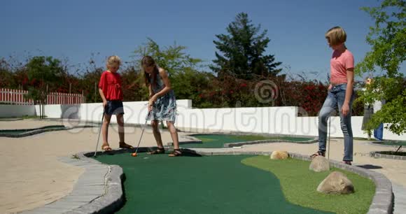 孩子们在花园里打迷你高尔夫视频的预览图