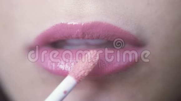 正在化妆的女人嘴唇上涂着粉红色的唇彩3840x2160视频的预览图