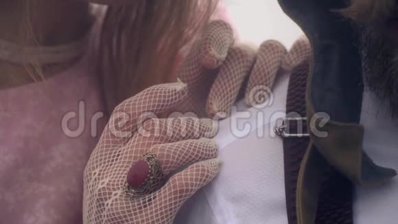 穿西装的男飞行员肩膀上戴花边手套的女性手视频的预览图