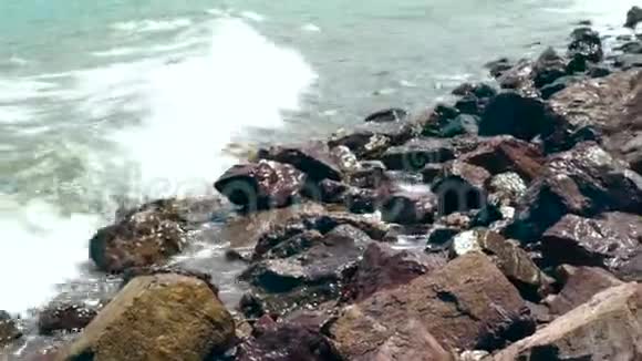 夏日里海浪拍打着岩石海滩关闭海浪溅在海洋海滩上美丽的海浪视频的预览图