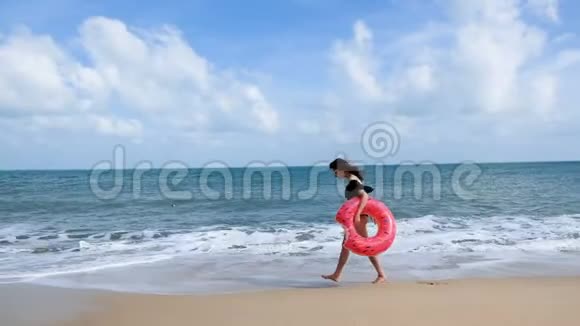 迷人的年轻女子与甜甜圈浮动玩得开心和享受暑假在热带海滩度假放松的女人视频的预览图