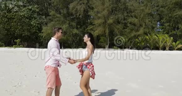 沙滩上的情侣拥抱亲吻青年男女在夏日度假快乐的游客视频的预览图