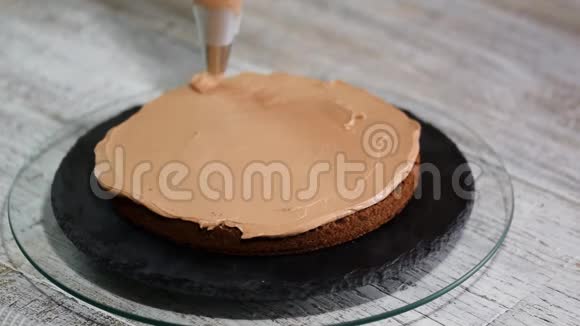 烤蛋糕把奶油挤在蛋糕上美味可口的美味奶油挤在蛋糕上视频的预览图