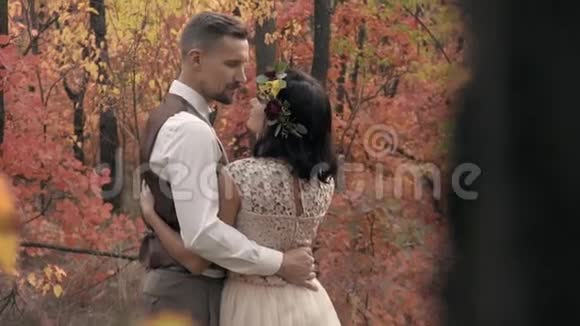 秋天森林里的树木中有一对相爱的夫妇的拥抱视频的预览图