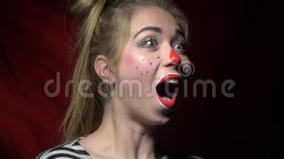 美丽的女人带着小丑的妆欢快地做着鬼脸视频的预览图