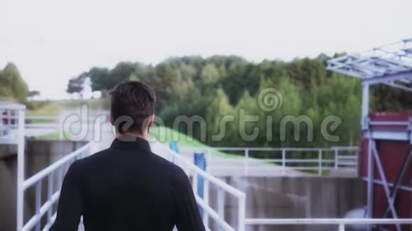 慢动作后景运动员享受慢跑年轻的健身教练在大坝桥上跑步以宁静的乡村景观视频的预览图