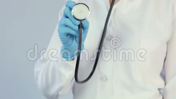 医生穿着实验室外套戴着医用手套拿着听诊器到照相机诊所视频的预览图