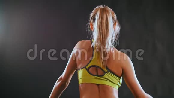 一位年轻的金发美女穿着运动服在健身俱乐部加强了脊柱的肌肉视频的预览图