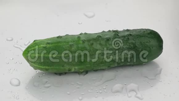 旋转水滴落在成熟的绿色黄瓜上视频的预览图