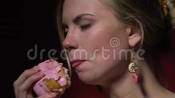 金发美女试着吃甜甜圈里的奶油有点慢动作视频的预览图