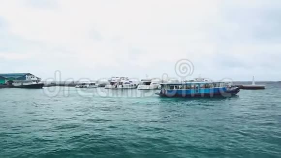 美丽的海港景色与船舶雅赫茨和公共渡轮青绿色的水蓝天白云马尔代夫马累视频的预览图