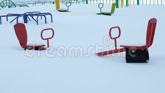 孩子们在冬天的雪地里玩跷跷板和旋转木马相机是静态的视频的预览图