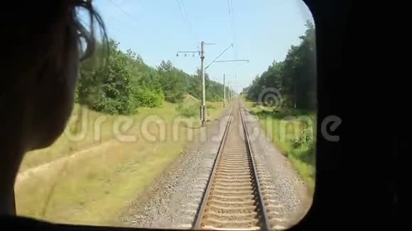 女人从火车车厢窗户望着铁轨离开视频的预览图
