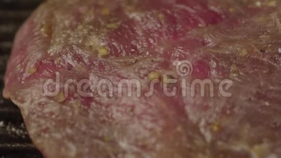 新鲜的猪肉牛排用芳香香料磨碎视频的预览图