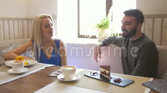 两个白种人在咖啡馆里享受甜点和交谈视频的预览图