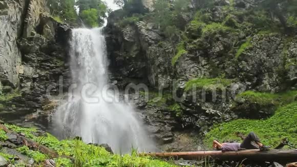 男游客在山瀑布附近休息野生视频的预览图