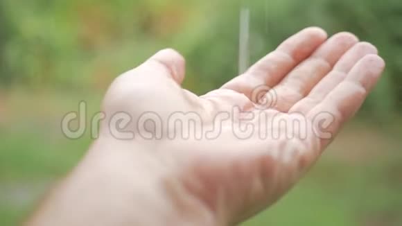 雨滴落在手中的雄性在雨中特写的手你看到水滴在他的手上跳动概念视频的预览图