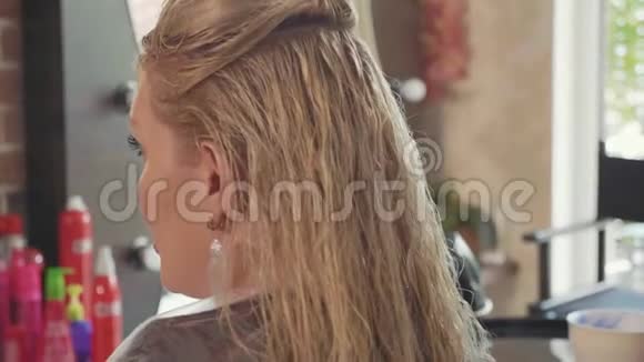 美容师正在美容美发中心为金发女性顾客理发视频的预览图