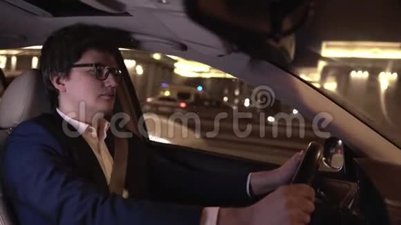 戴眼镜的英俊年轻商人在夜城开车视频的预览图