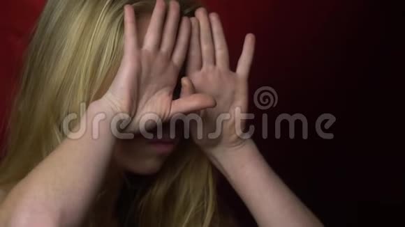 美丽的女孩用双手做鬼脸露出舌头视频的预览图