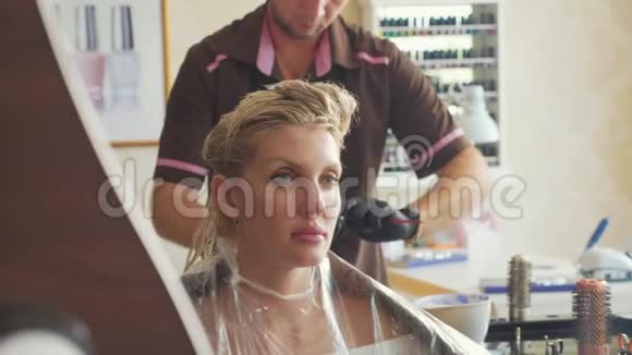 一位年轻的金发女子在美容美发厅的手术画像视频的预览图