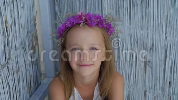 幸福的小微笑女孩的肖像坐在一半看着相机4K视频的预览图