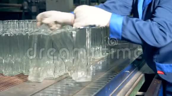 工厂员工正在把玻璃瓶放到传送带上视频的预览图