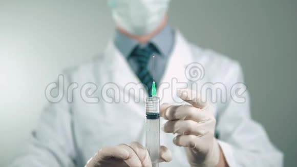 医生穿着白色的实验室外套和口罩准备一个注射器用于注射药物视频的预览图