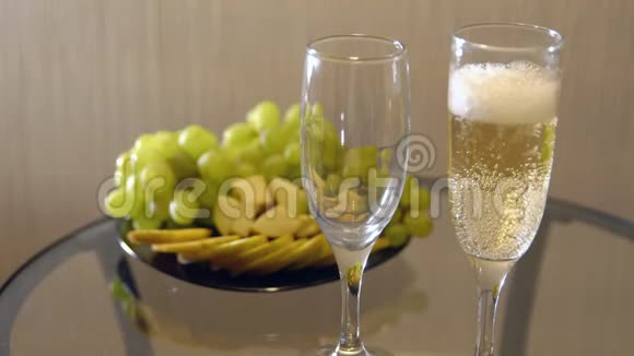 浪漫的约会在带水果的桌子上用杯子洒香槟视频的预览图