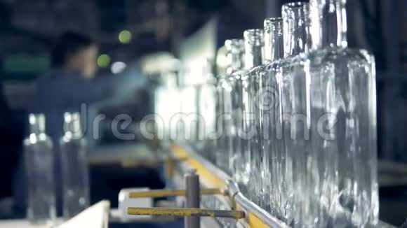 透明瓶是由工厂工人在后台检查和调整的视频的预览图