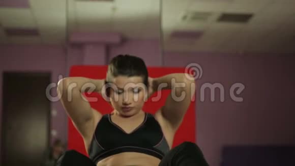 年轻的女士做平腹锻炼在健身课上努力锻炼身体视频的预览图