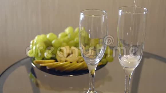 浪漫的约会在带水果的桌子上用杯子洒香槟视频的预览图